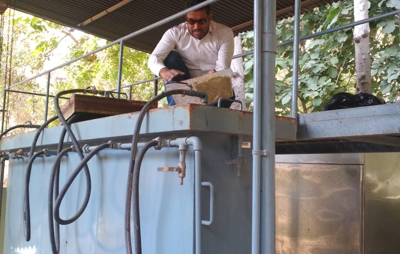 An engineer charging the pilot reactor with rice straw at the TERI University pilot plant